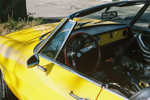 Detail of an oldtimer cabriolet car in bright yellow photo