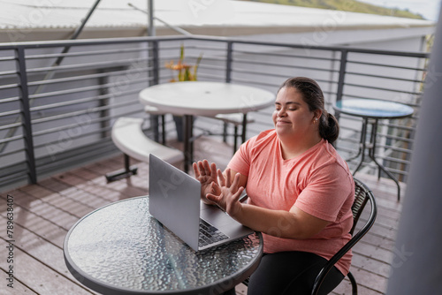 A woman with down syndrome works on her laptop photo