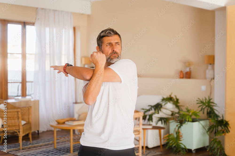 Senior Man With Gray Hair Stretching At Home Senior Man With Gray Hair Stretching At Home