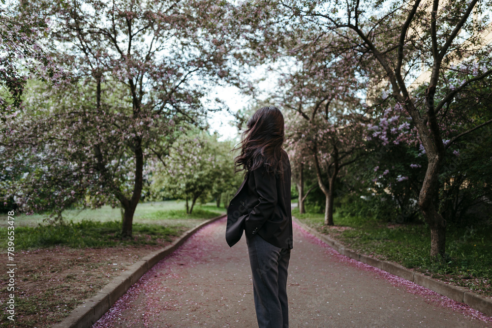 Faceless famale admires flowering of trees. Faceless famale admires flowering of trees.