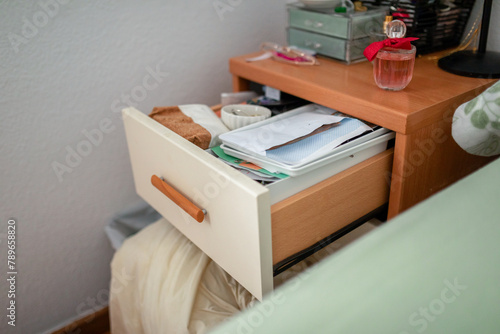 nightstand drawer open and full of things photo