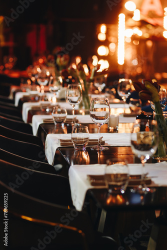 Beautifully organized event - round served table banquet ready for guests, round decorated table with empty plate, glasses, forks, napkin. Elegant dinner table 
