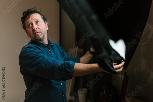 Adult man adjusting equipment in photo studio photo