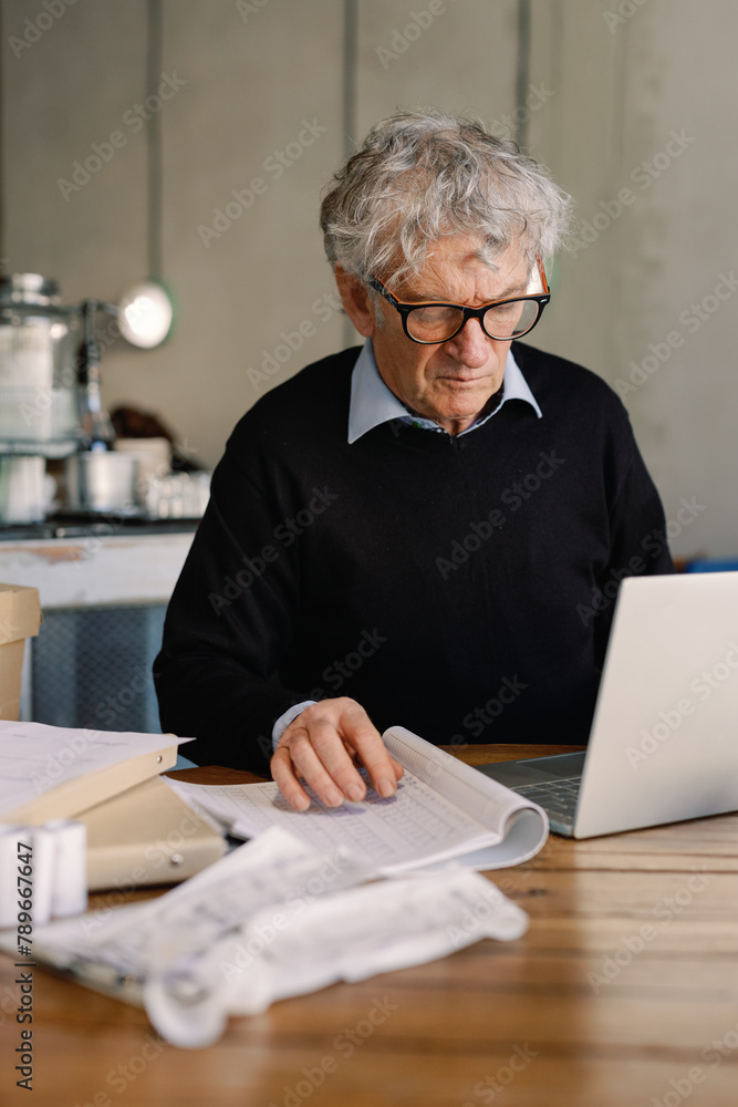 Senior Businessman Working on Project in Cafe
Senior Businessman Working on Project in Cafe