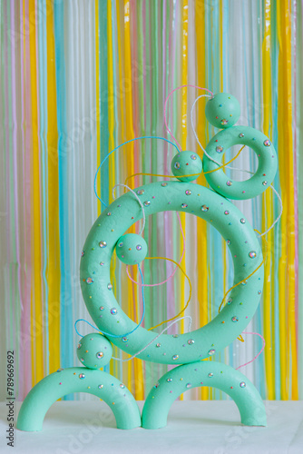 Green colored torus with with sparkles, beads on a coloured background