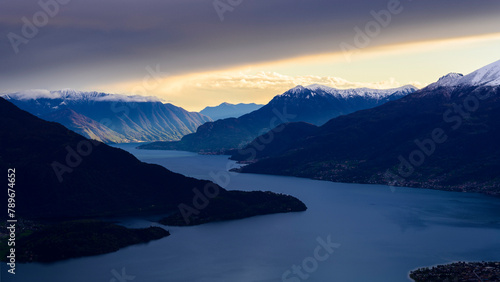 Sun beams light the mountains over Como lake