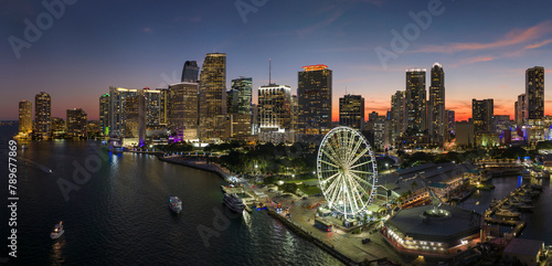 American urban landscape at night. Skyviews Miami Observation Wheel at Bayside Marketplace with reflections in Biscayne Bay water and high illuminated skyscrapers of Brickell, city's financial center