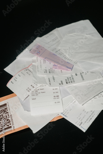 Assorted Shopping Receipts Scattered on a Black Background