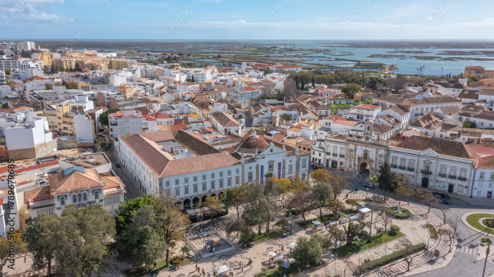 Traditional Portuguese town of Faro with old architecture, filmed by drone. Arco de villa and largo de se. Ria formosa in background.