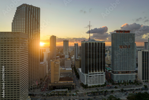 Evening urban landscape of downtown district of Miami Brickell in Florida USA. Skyline with dark high skyscraper buildings and street with cars and Metrorail traffic in modern american megapolis