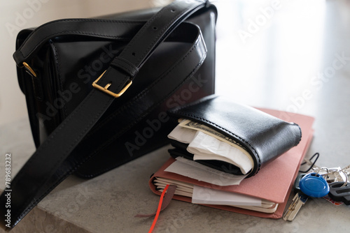 Handbag, messy wallet with receipts and cash money, notebook and keys photo