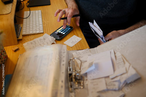Man organizing receipts for his business tax report in home office photo