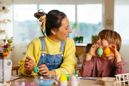 Family preparing eggs for Easter at home photo