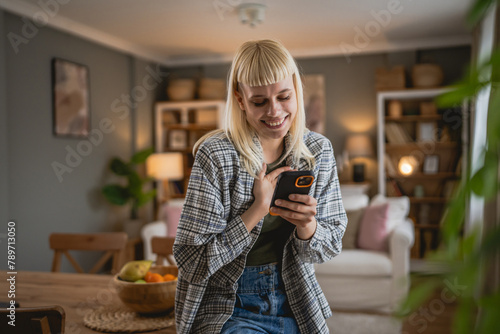 Young woman text message and browse internet on mobile phone at home