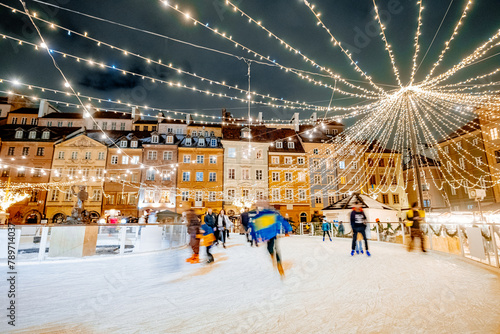 A beautiful crowded outdoor ice rink in the old European city photo