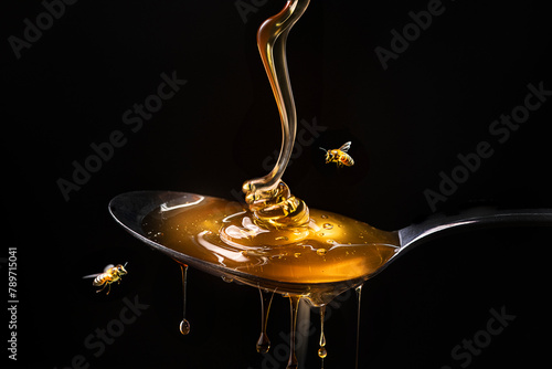 Honey dripping from spoon photo