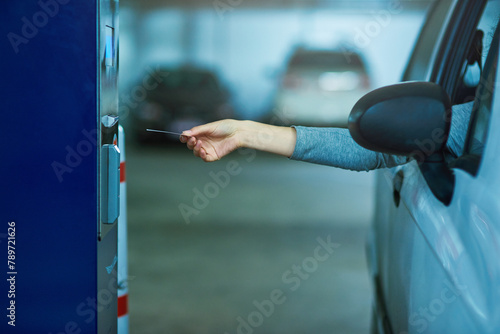 Parking lot, car and hand with ticket meter for payment, cost and access for security, safety or garage space compliance. Machine, card or driver with vehicle permit pass for toll, barrier or fees photo