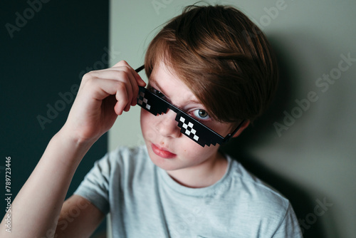 Disaffected boy in pixel sunglasses.