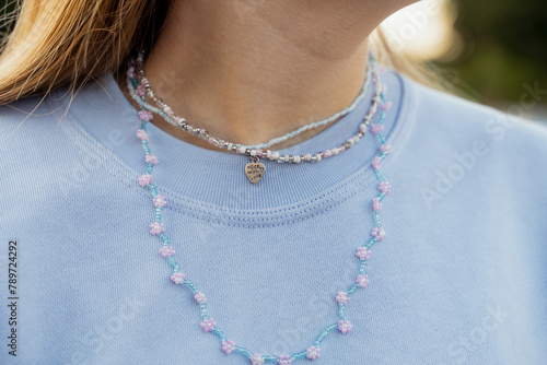Close-up of handmade beads necklace on teenager girl outdoors. 