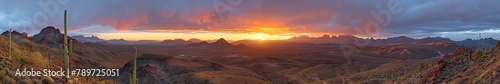 Expansive Panoramic View of Desert Sunset with Dynamic Skies and Rugged Terrain