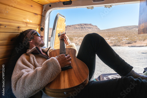 Man playing his guitar in camper van photo