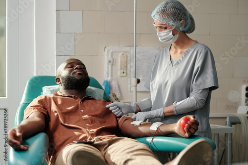 Medical Worker Using Tourniquet On Mans Arm photo