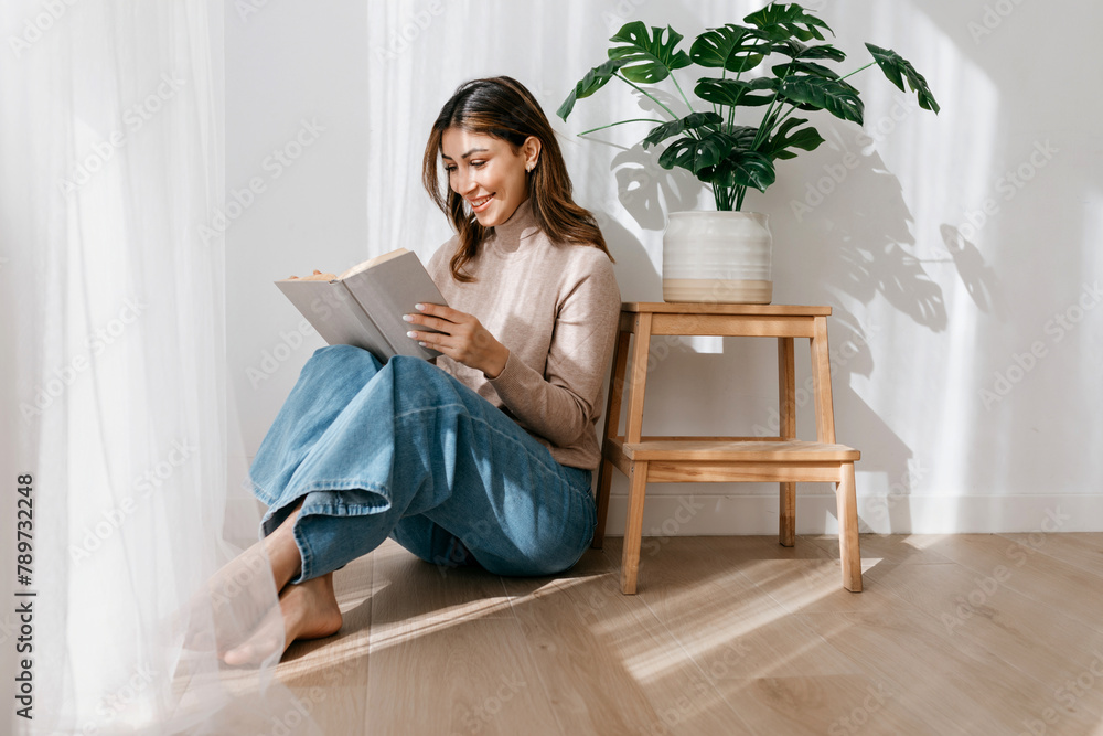 Cheerful woman reading interesting story while sitting Cheerful woman reading interesting story while sitting