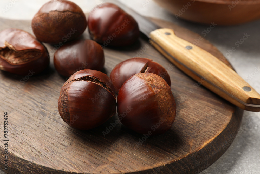 Fresh edible sweet chestnuts on grey table, closeup Fresh edible sweet chestnuts on grey table, closeup