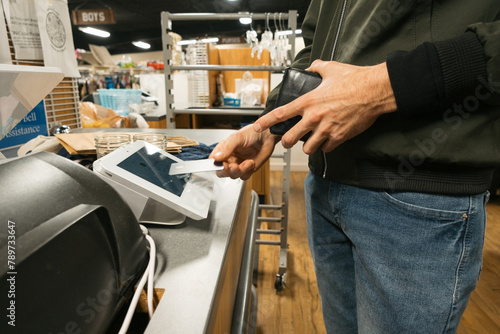 Person Paying in Store by Tapping a Contactless Credit Card photo