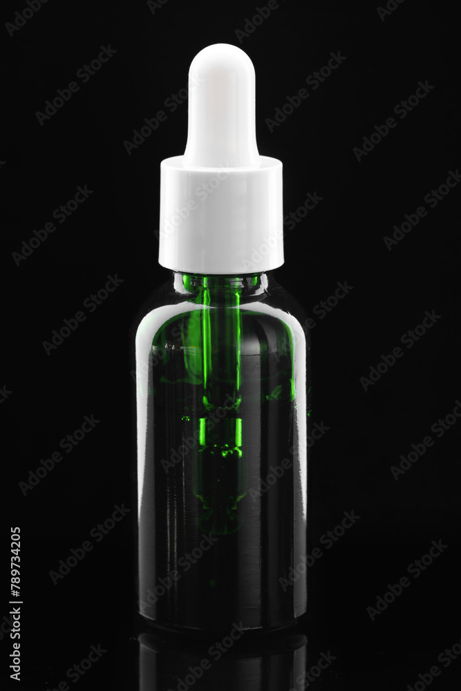 Tincture in bottle on mirror table against dark background Tincture in bottle on mirror table against dark background