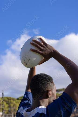 African American young male athlete holding a rugby ball, ready to throw, copy space © WavebreakMediaMicro