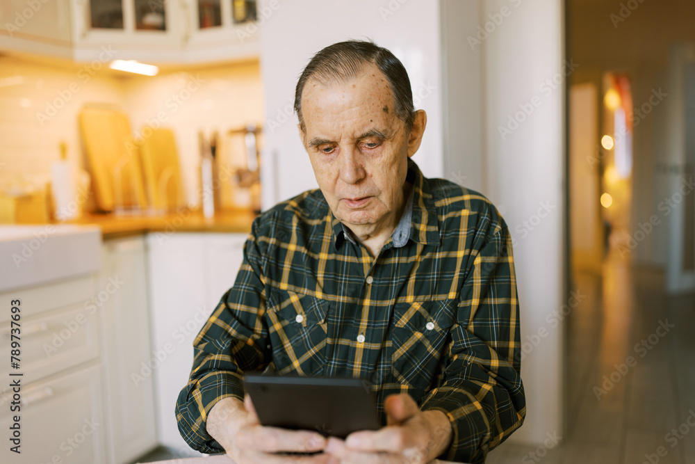 Senior man using modern digital tablet at home for video call Senior man using modern digital tablet at home for video call