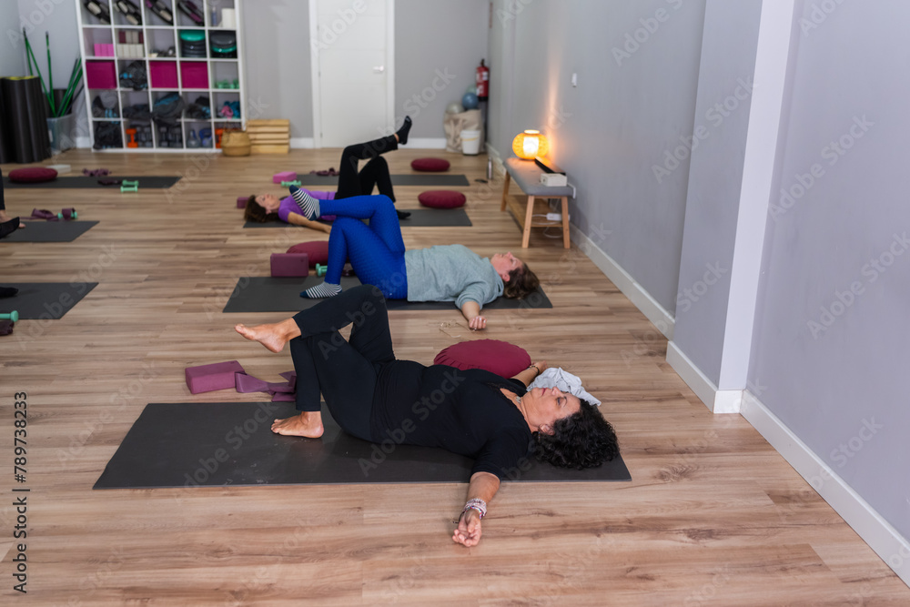 senior women in various relaxation poses during a yoga session. senior women in various relaxation poses during a yoga session.