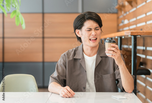 Schilderij op canvas 不味そうにコーヒーを見つめるアジア人男性（まずい・がっかり・失敗・睨む）