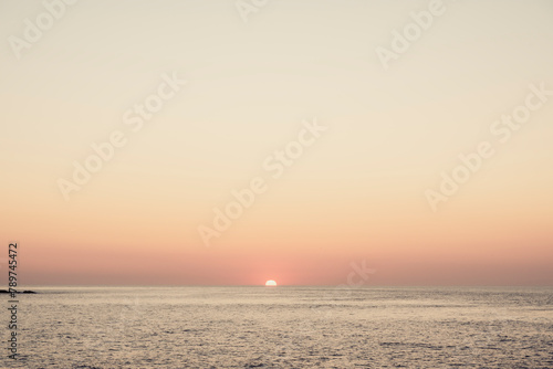 Sun setting on the horizon at sea from St Ives photo