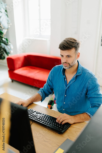 Portrait of a man using desktop computer in modern office  photo