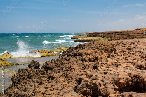 un lugar al norte de la guajira colombiana, llamado playa arco iris, donde la olas golpean con impetu contra las rocas o acantilados, dando lugar a colores muy hermosos. photo