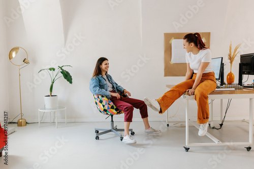 Two young female generation z having fun in office  photo