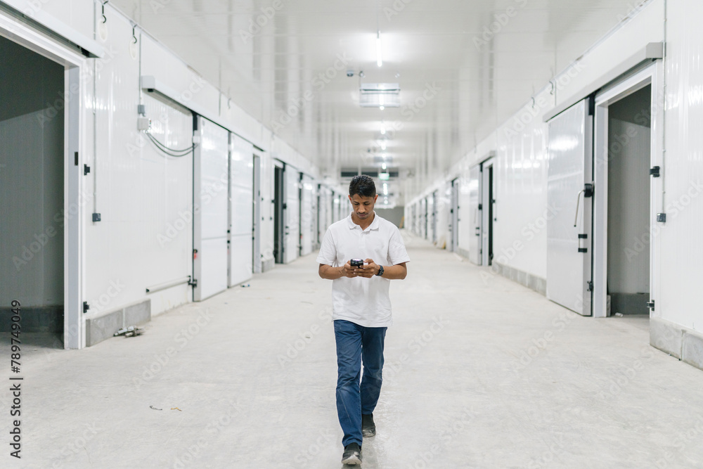 Man walking with smartphone in spacious corridor Man walking with smartphone in spacious corridor