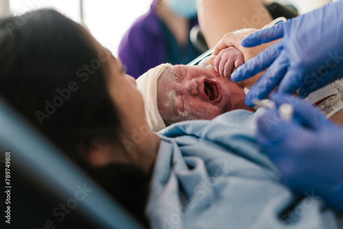 Anonymous doctor examining newborn in hospital photo