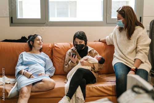 Women visiting mother and infant in hospital photo