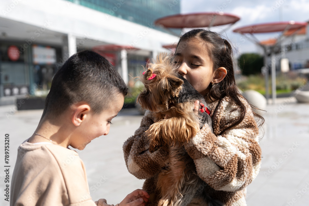 Girl Kisses Yorkie In Sunny City Plaza. Girl Kisses Yorkie In Sunny City Plaza.