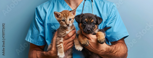 A smiling veterinarian in blue scrubs holds two puppies and a kitten, symbolizing care and compassion for animals.
