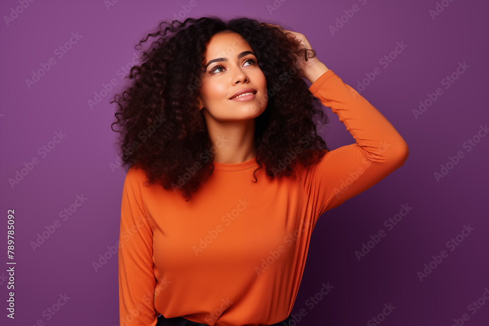 A dreamy expression lights up the face of a woman with lush curly hair, hand in hair, set against a vibrant purple backdrop, conveying a mood of contemplation and ease. A dreamy expression lights up the face of a woman with lush curly hair, hand in hair, set against a vibrant purple backdrop, conveying a mood of contemplation and ease.