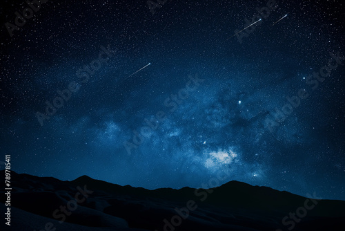 The Milky Way dazzles in the night sky above a stark silhouette of jagged mountain peaks, with a shooting star streaking by.