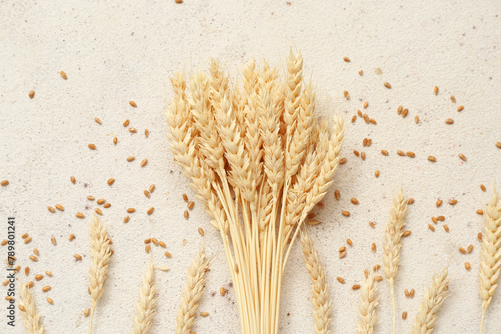 Obraz premium Bundle of wheat ears and grains on white table