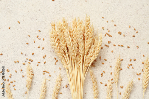Bundle of wheat ears and grains on white table