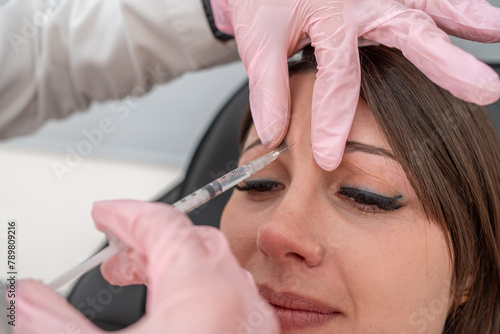 фотографія Beautician injecting Botox for eye wrinkle rejuvenation in forehead area, target