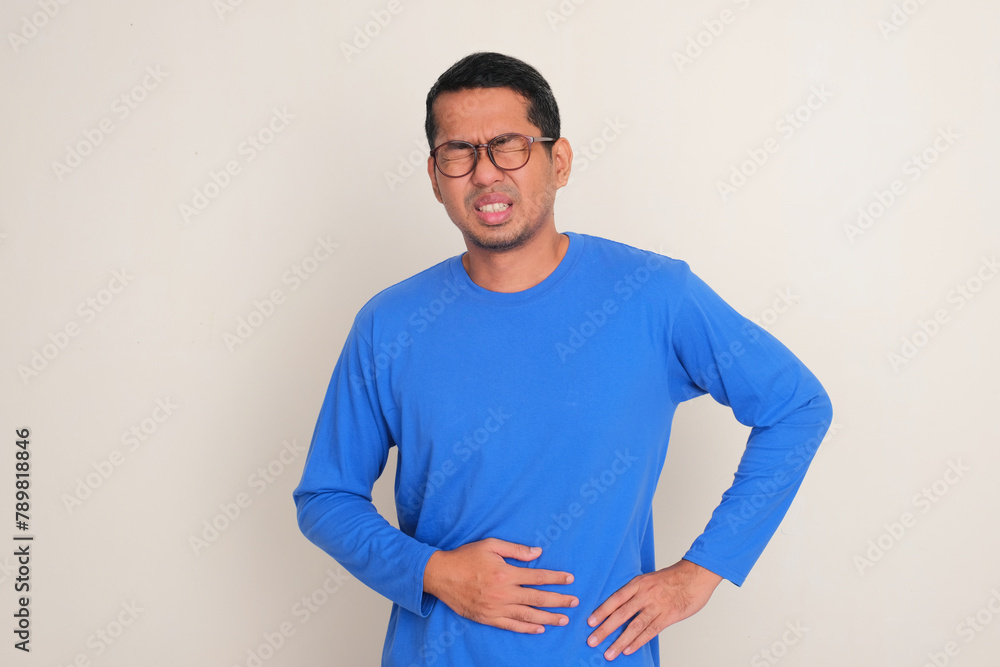 Obraz premium A man touching his stomach showing in pain expression