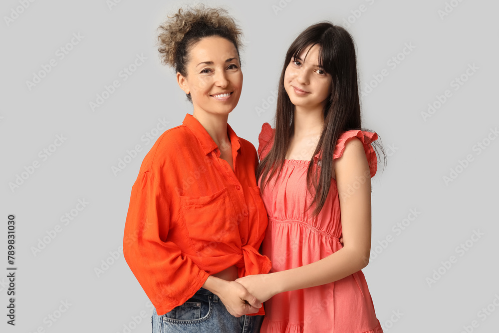 Beautiful mature woman with her teenage daughter on grey background. Mother's day Beautiful mature woman with her teenage daughter on grey background. Mother's day